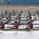 Men rowing down the Sydney Harbour passing The Macleay Hotel