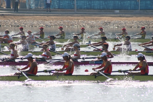 Men rowing down the Sydney Harbour passing The Macleay Hotel